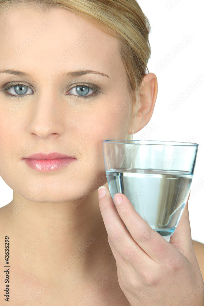 Blond woman with glass of water in hand Blond woman with glass of water in hand