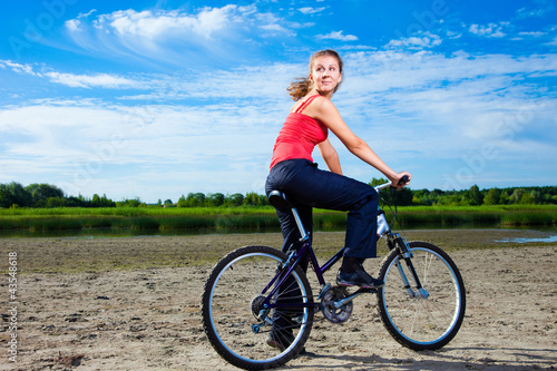 beautiful woman with bicycle at the sea