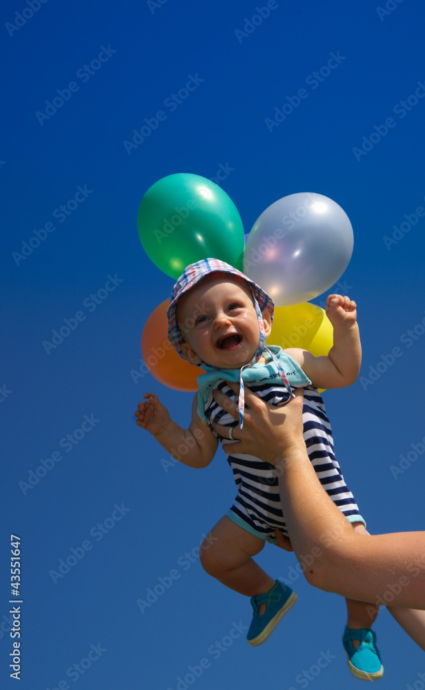 Fototapeta premium bébé souriant sur fond de ciel bleu