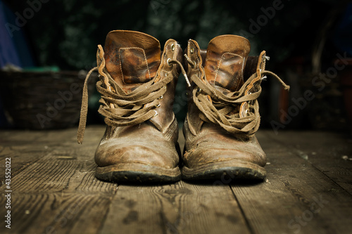 Pair of old boots on wooden floor boards