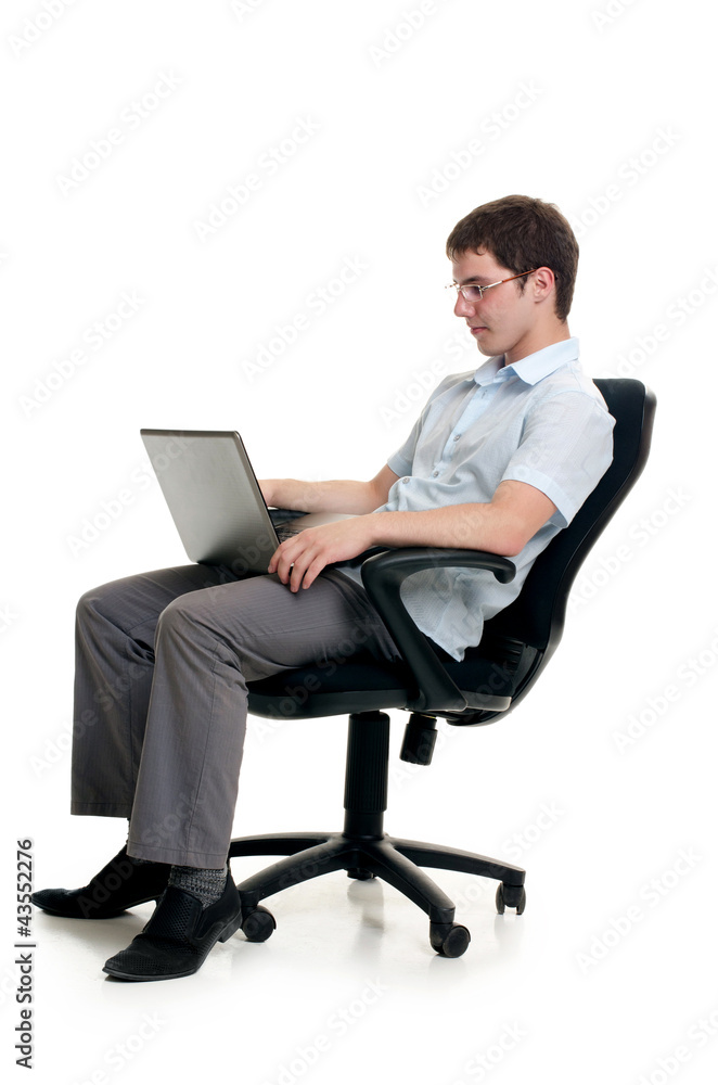 The businessman sits in an armchair with laptop The businessman sits in an armchair with laptop