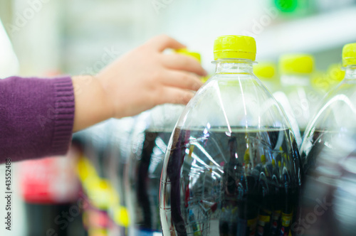 Bottles with soda drinks in supermarket