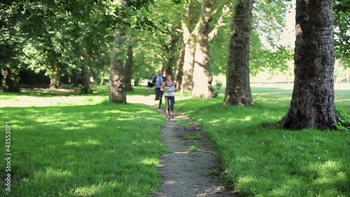 Wallpaper Mural Businessman and woman jogging in park, slow motion Torontodigital.ca