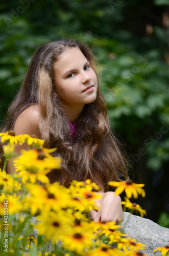 beautiful young brunette girl relaxing with yellow flowers