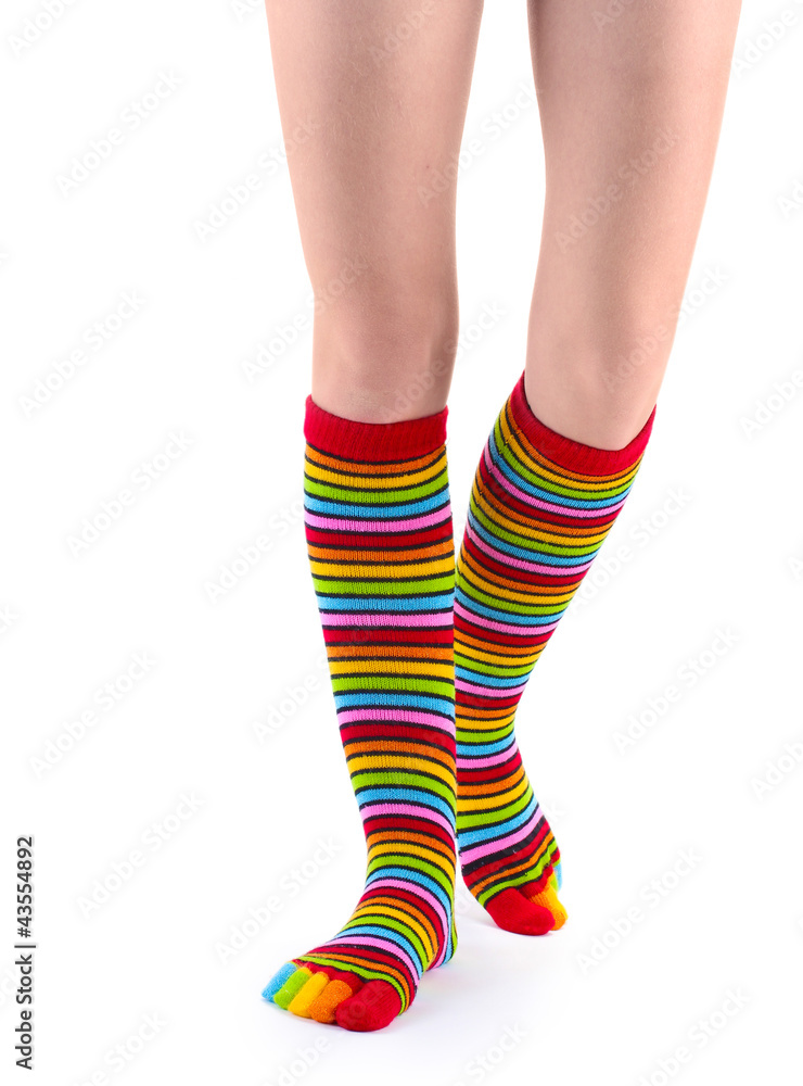 female legs in colorful striped socks isolated on white female legs in colorful striped socks isolated on white