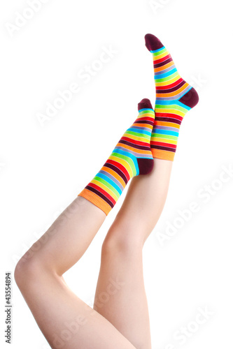 female legs in colorful striped socks isolated on white