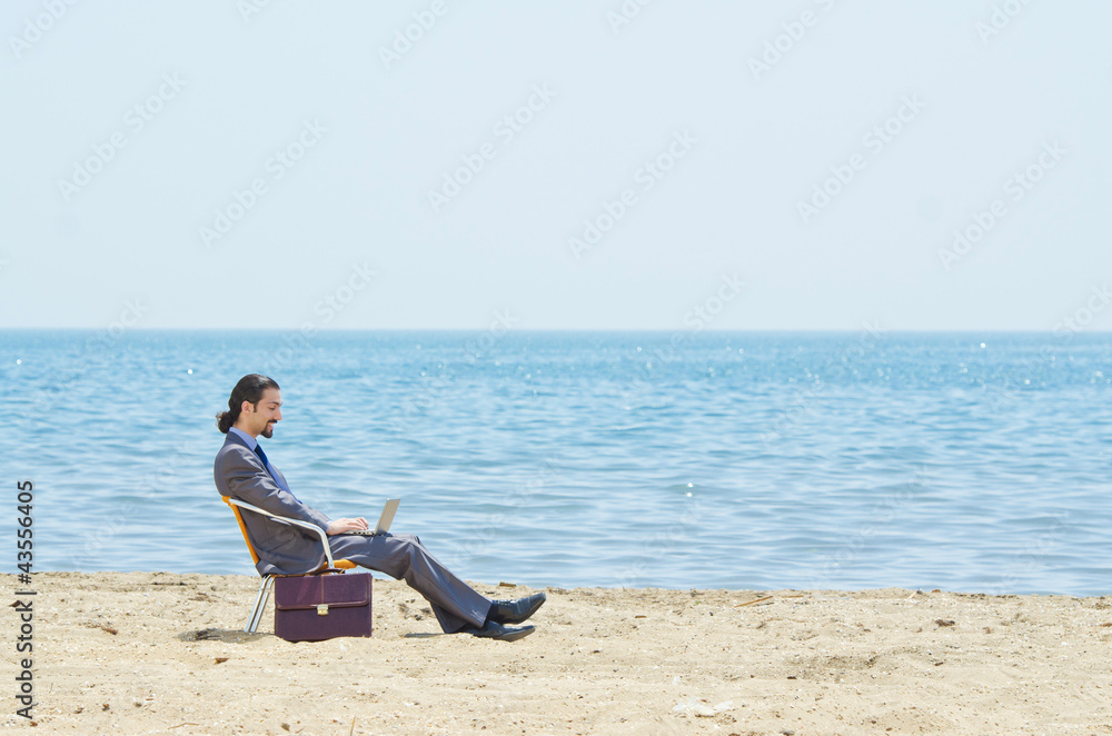 Businessman working on laptop on seaside Businessman working on laptop on seaside