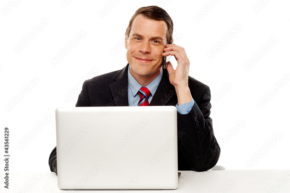 Businessman working and talking on cell phone Businessman working and talking on cell phone