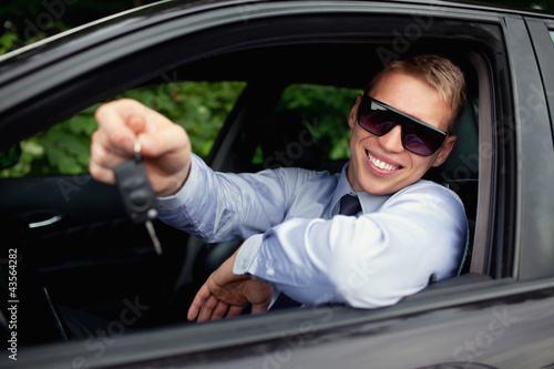 Young man buying new car, smiling