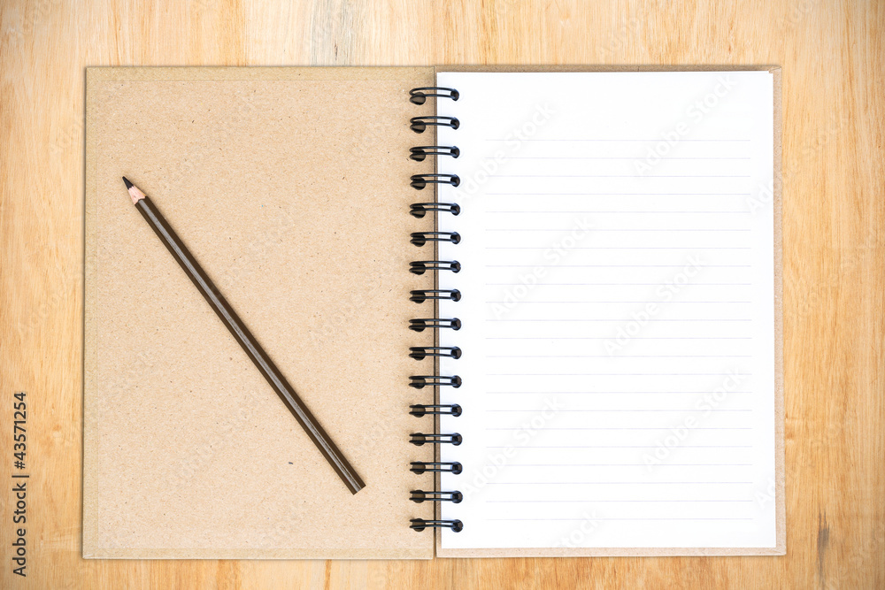 White notebook with frangipani flower on the wood White notebook with frangipani flower on the wood