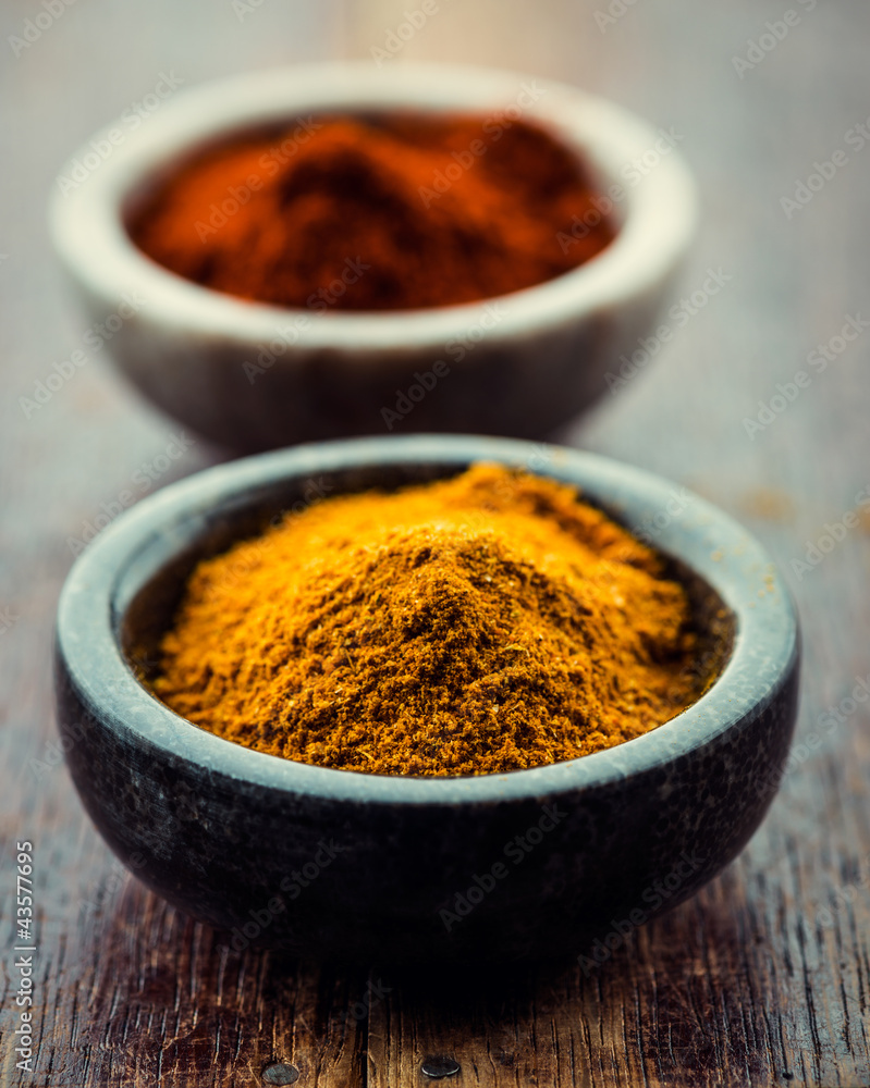 Curry powder and chili pepper in small containers Curry powder and chili pepper in small containers