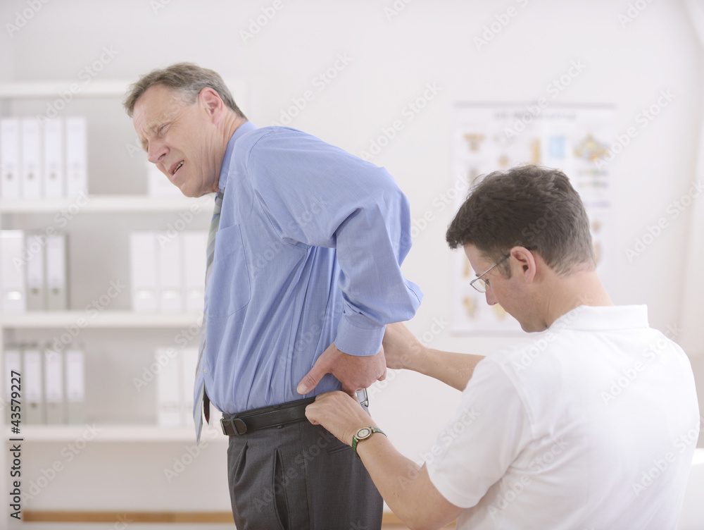 Obraz premium Physiotherapy: Physiotherapist examining senior man