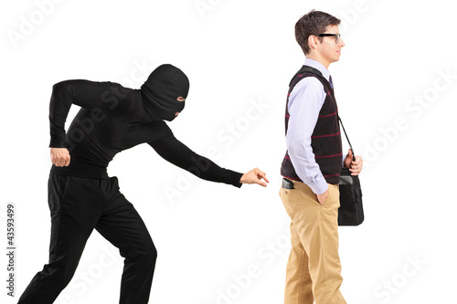 A pickpocket with mask trying to steal a wallet photo
