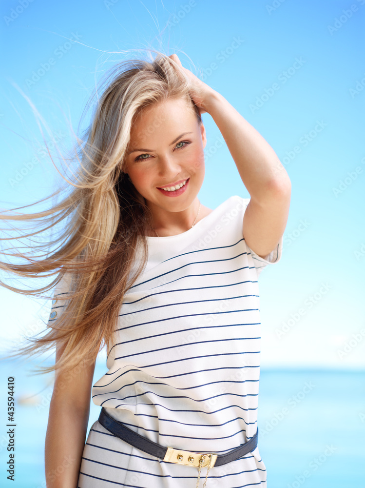 Young attractive woman near the ocean on a summer day