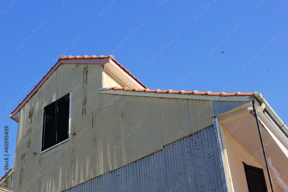 corrugated steel white painted wall barn with wooden louvre shutter windows. corrugated steel white painted wall barn with wooden louvre shutter windows.