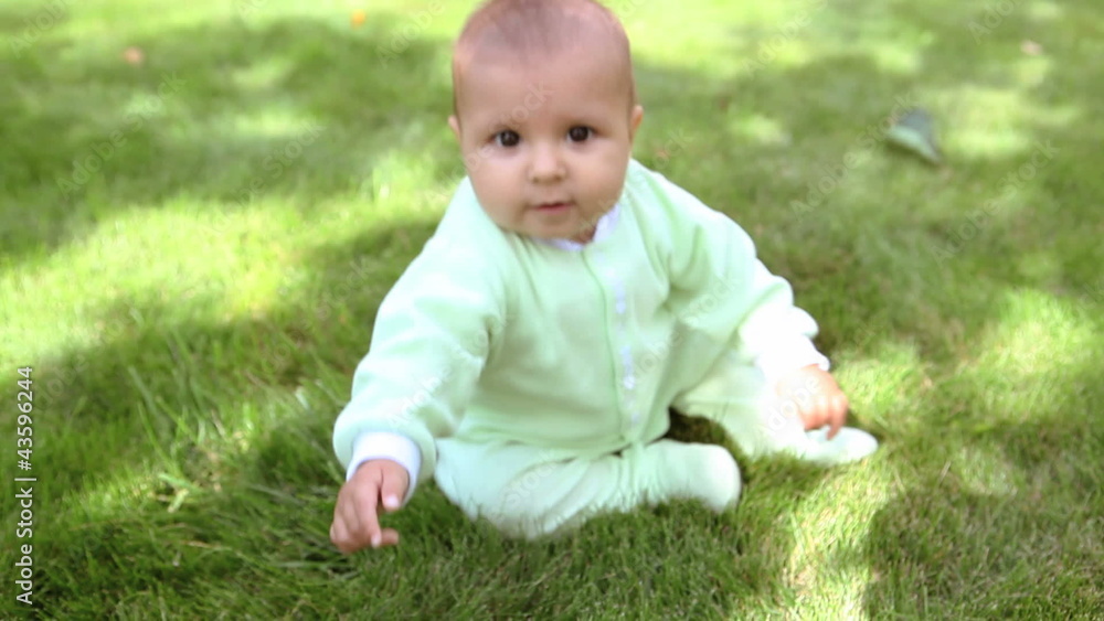 Happy small boy sitting on the green grass Happy small boy sitting on the green grass