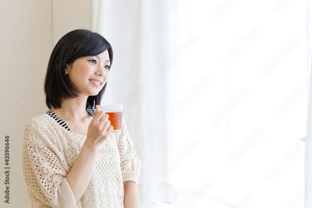 a young asian woman drinking tea a young asian woman drinking tea
