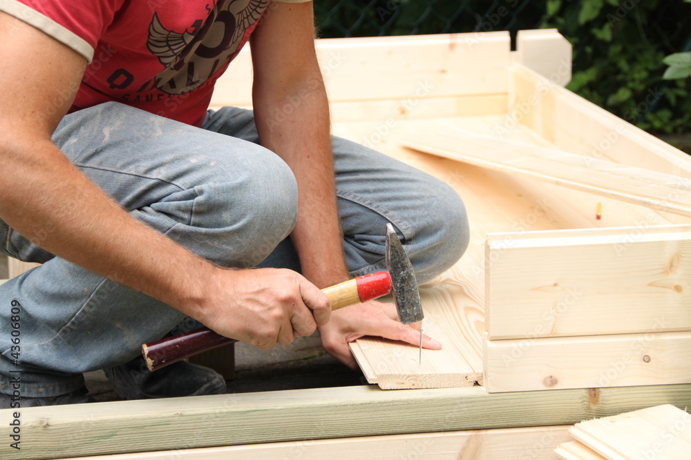 Mann beim Aufbau eines Gartenhauses Stock Photo | Adobe Stock