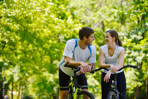 Happy couple riding bicycle outdoors