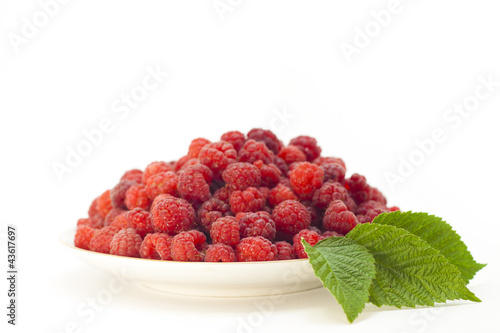 ягода малина с листочками на тарелке