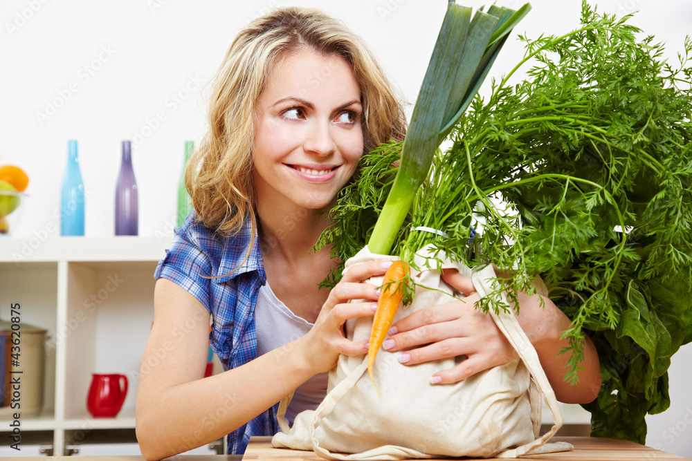 Obraz premium Lachende Frau mit Bio-Gemüse