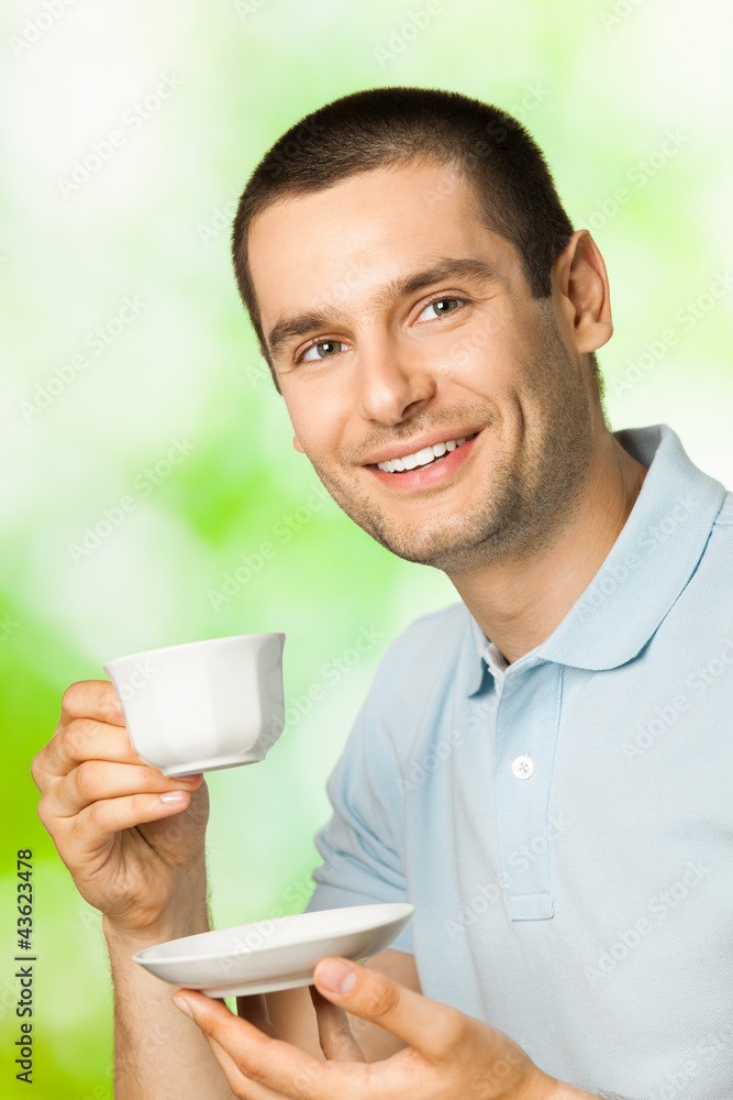 Happy smiling man drinking coffee, outdoors Happy smiling man drinking coffee, outdoors
