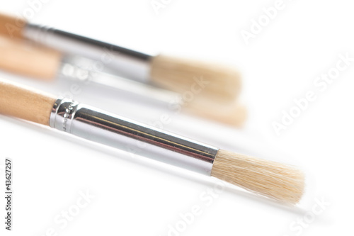 Three bright brushes are lying on white background, isolated