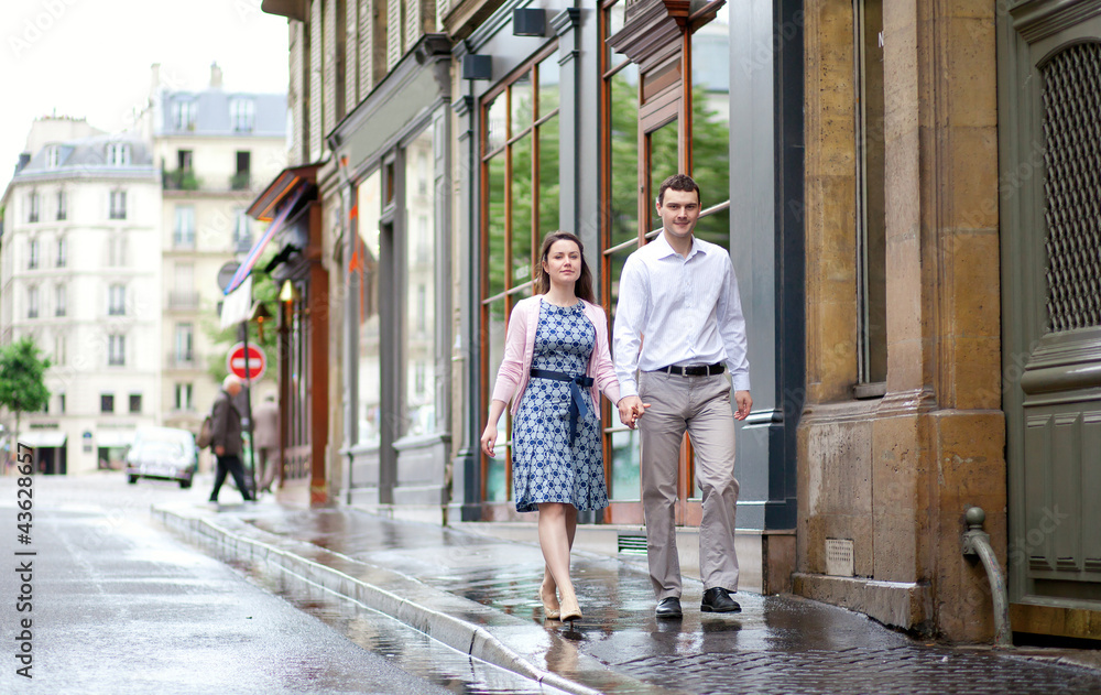 Dating couple walking in Paris after the rain