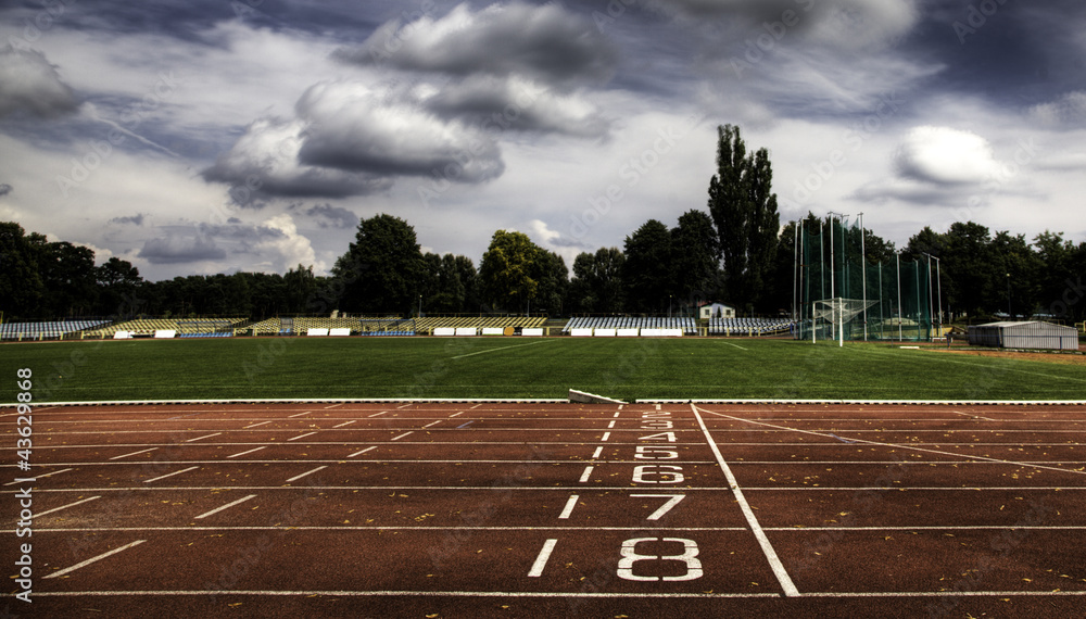 Obraz premium Running track numbers in front of tracks and stadium with blue s