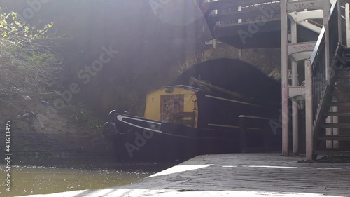 Backlit tracking shot of a barge coming out of a tunnel. photo