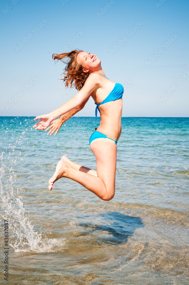 Naklejka premium young girl jumping out of a water