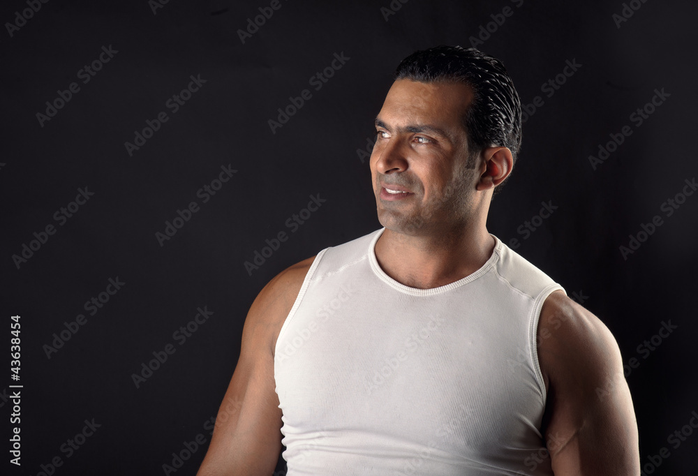 Athletic man smiling and posing against a black background Athletic man smiling and posing against a black background
