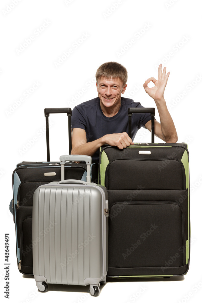 Tourist man with his travel suitcases showing OK sign Tourist man with his travel suitcases showing OK sign