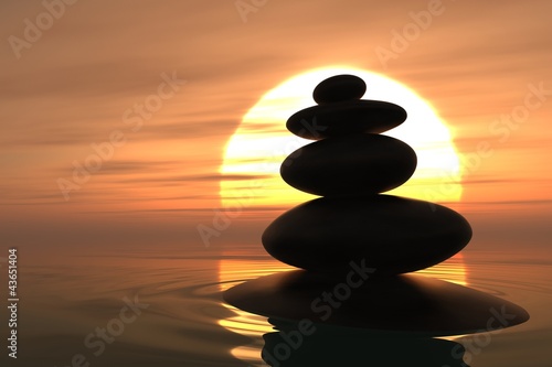 Zen pebbles stacked in sunset