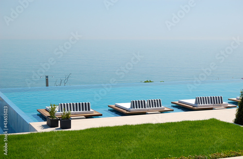 Infinity swimming pool by beach at the modern luxury hotel, Pier