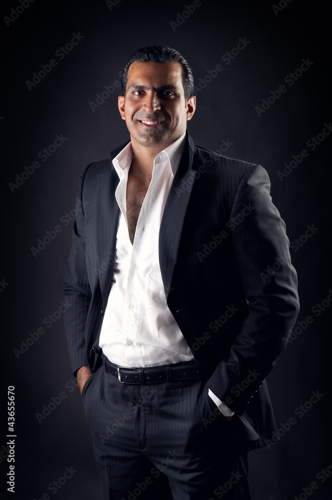 Fototapeta premium Cool businessman posing against a black background
