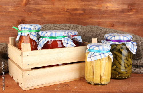 Jars with canned vegetables on wooden background close-up