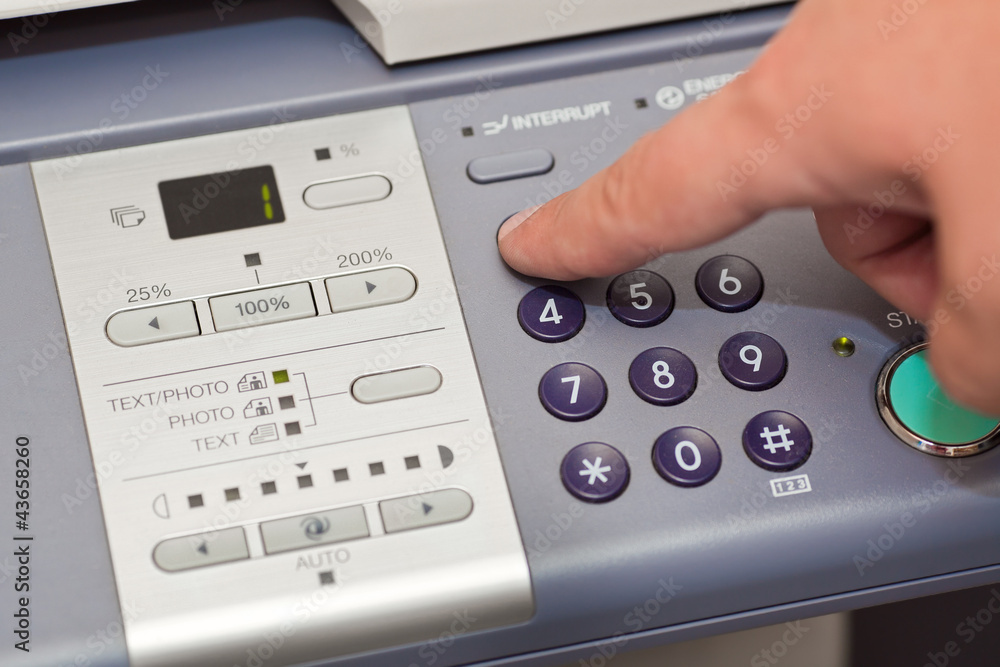 finger pressing the buttons of the copier finger pressing the buttons of the copier