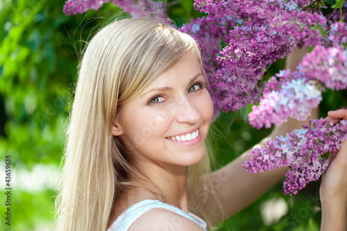 Smiling beautiful woman with violet flowers photo