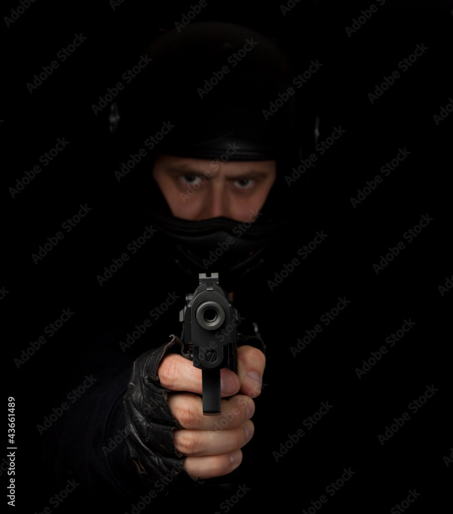 Armed assassin with motorcycle helmet aiming into the camera Armed assassin with motorcycle helmet aiming into the camera