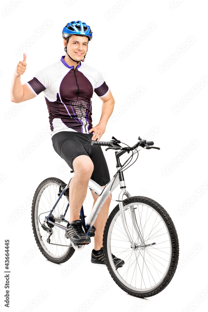Smiling bicyclist posing on a bicycle and giving a thumb up Smiling bicyclist posing on a bicycle and giving a thumb up