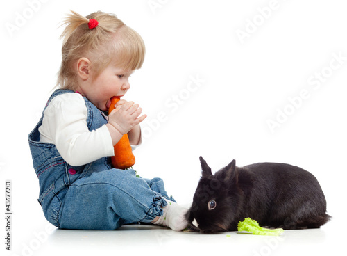 Smiling little girl eating ...