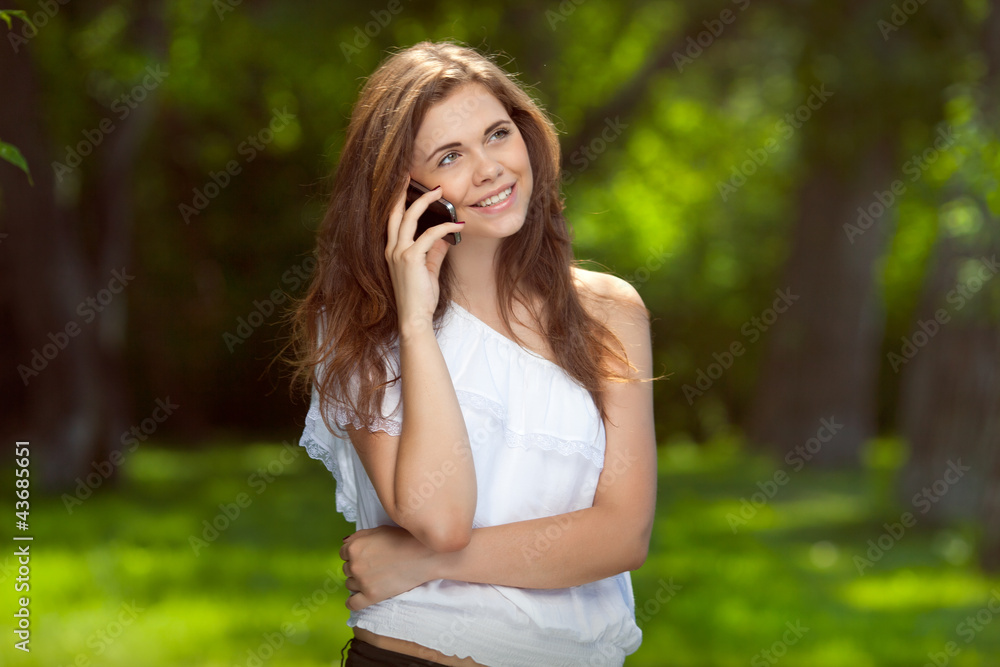 Young beautiful girl talking on the phone outdoors Young beautiful girl talking on the phone outdoors