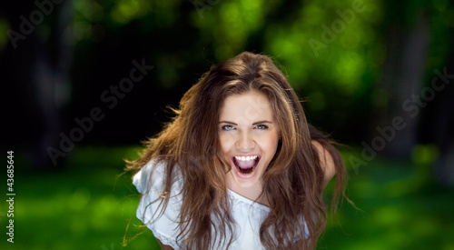 Portrait of a beautiful young girl who shouting outdoor