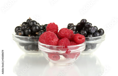 Fresh berries in transparent bowls isolated on white