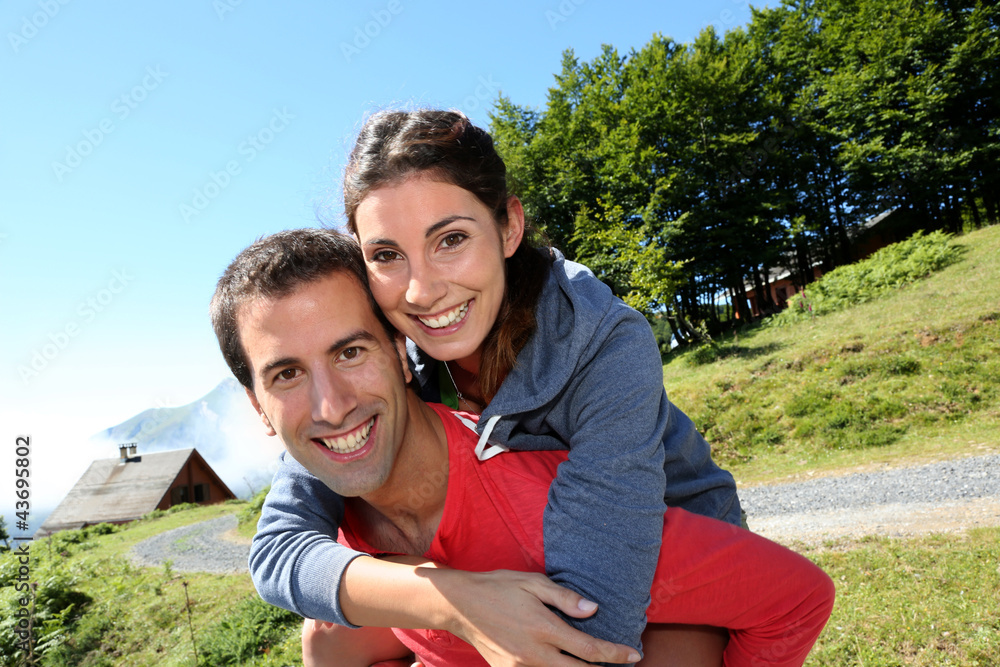 Man giving piggyback ride to girlfriend on a trekking day Man giving piggyback ride to girlfriend on a trekking day