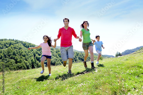 Happy family enjoying and running together in the mountains