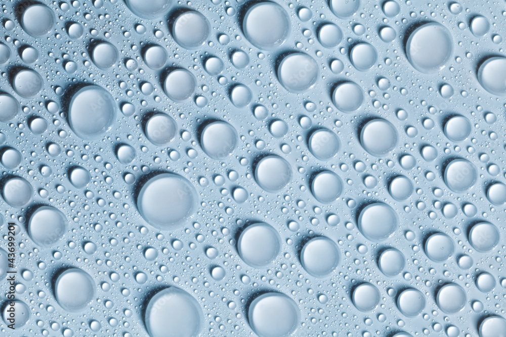 Voluminous water drops on a blue and smooth surface
