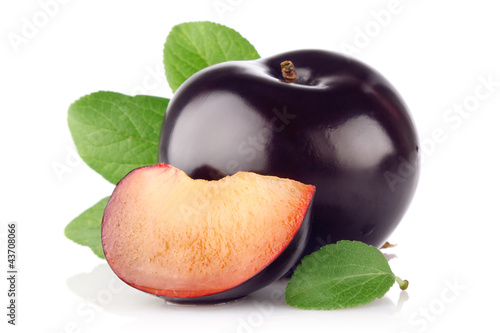 ripe juicy plum with green leaf