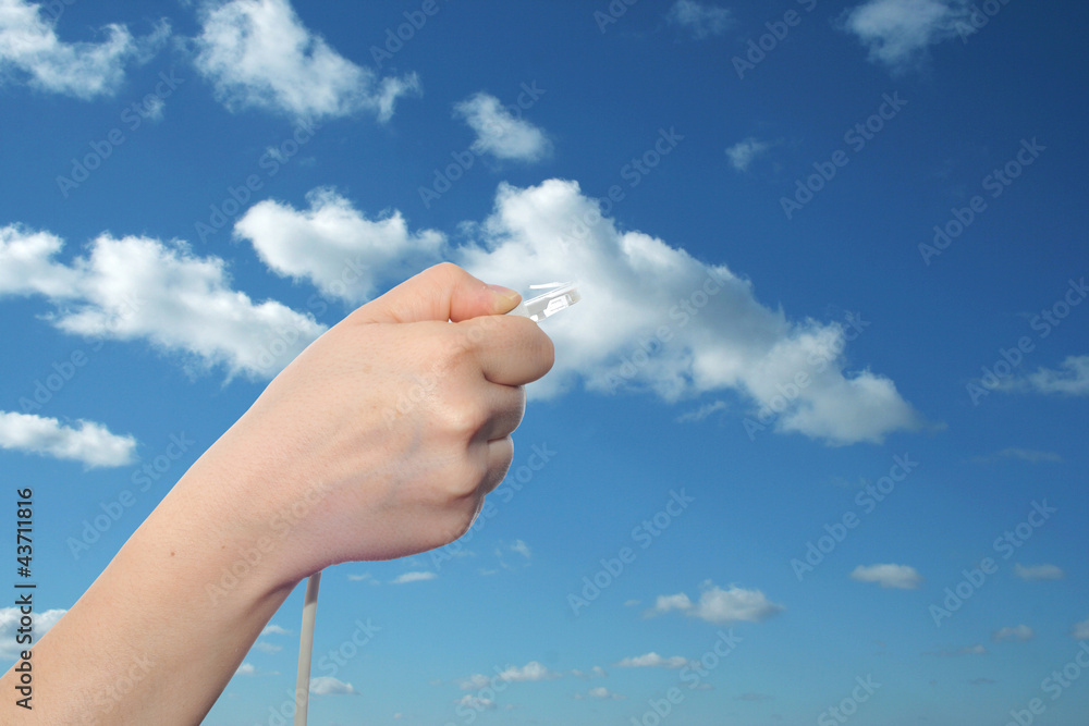 Conceptual human hand holding a internet data cable in clouds